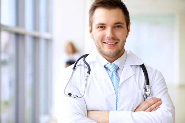 Smiling doctor waiting for his team while standing upright