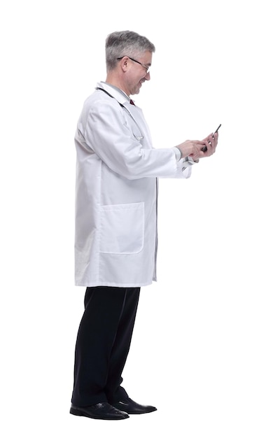 Smiling doctor with smartphone looking forward isolated on a white