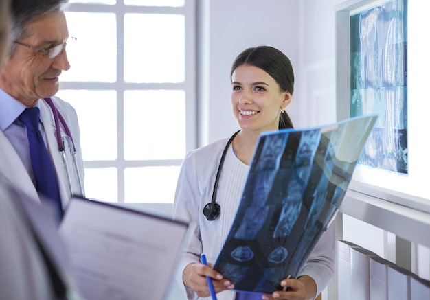 Smiling doctors discussing patient's diagnosis looking at xrays in a hospital