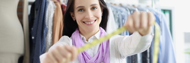 Smiling dressmaker woman willing to tape measure you find out clothes size