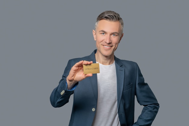 Smiling elegant man showing credit card