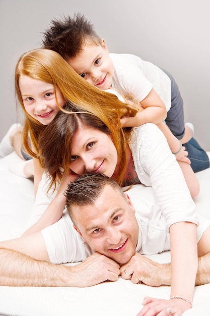 Smiling family having fun lying on the bed