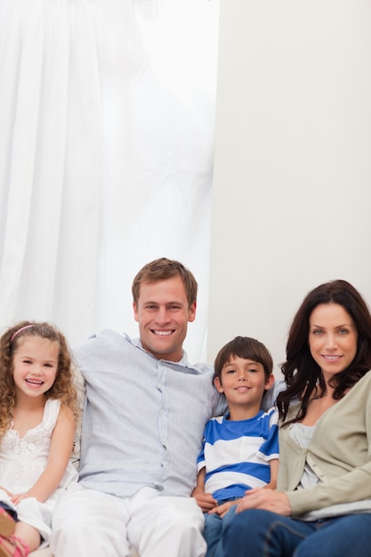 Smiling family sitting on the sofa together