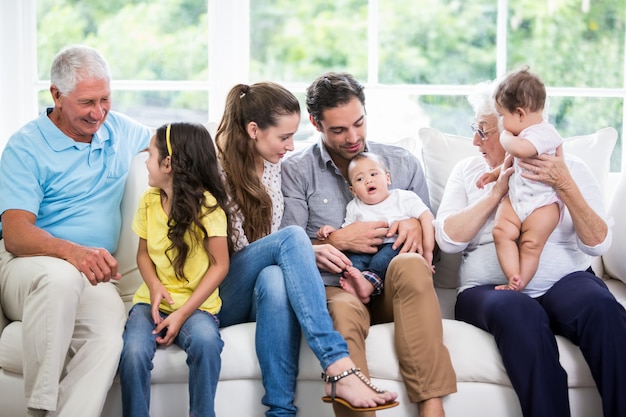 Smiling family with grandparents sitting on sofa