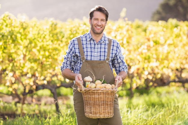 Smiling farmer holding a basket of potatoes