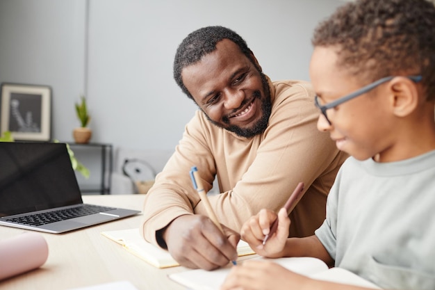 Smiling Father Helping Son Studying