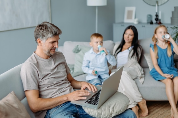 Smiling father using a laptop in a cozy living room