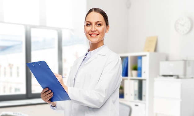 smiling female doctor with clipboard at hospital