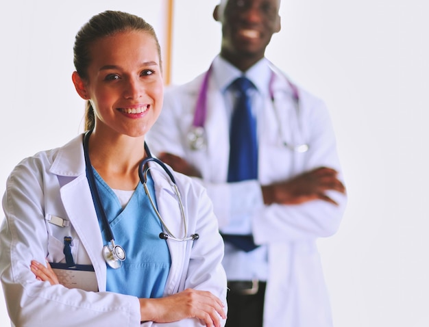 A smiling female doctor with a folder in uniform indoors