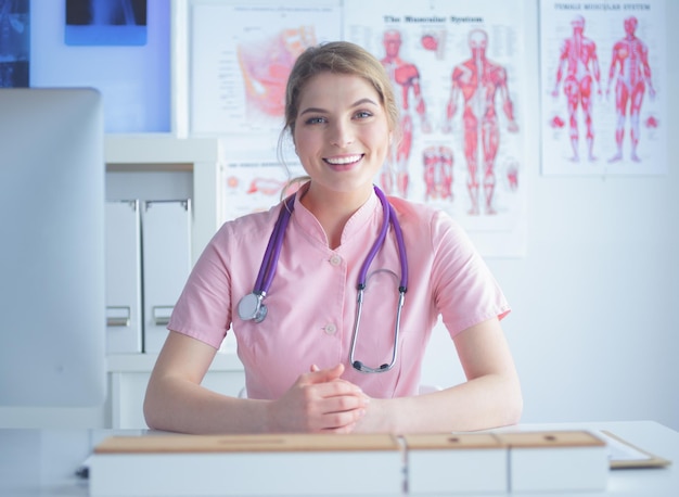 Smiling female doctor with a folder in uniform standing