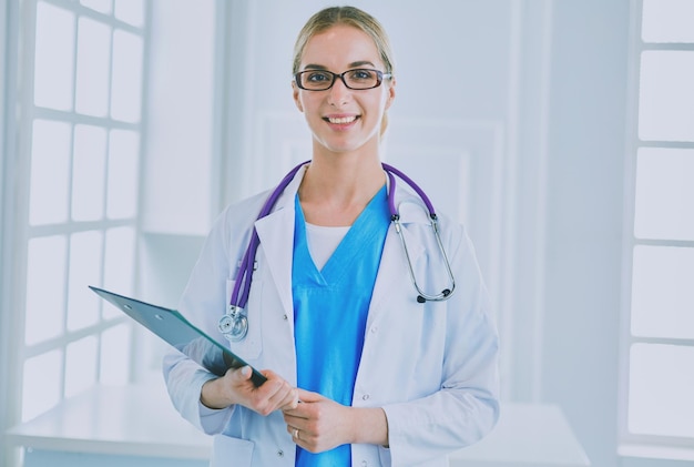 Smiling female doctor with a folder in uniform standing