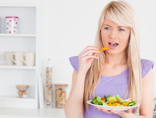 Smiling female eating her salad 