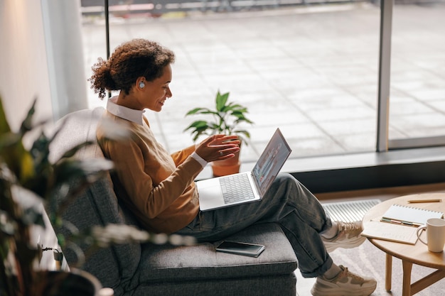 Photo smiling female freelancer have video conference with client while sitting in cozy coworking