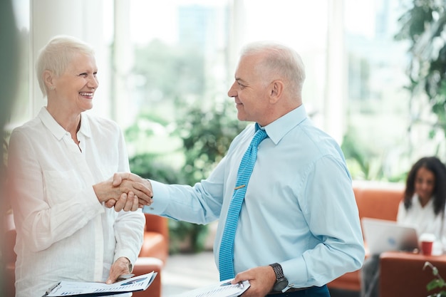 Smiling financial partners shaking hands close up