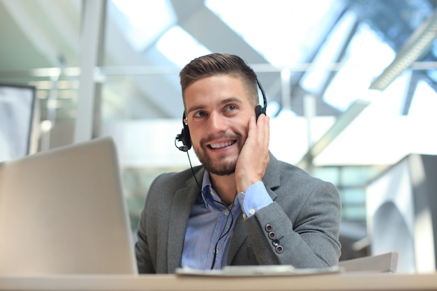 Smiling friendly handsome young male call centre operator.