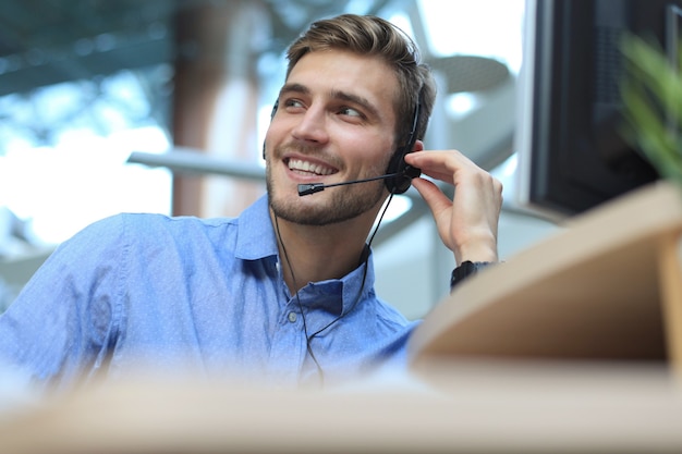 Smiling friendly handsome young male call centre operator.