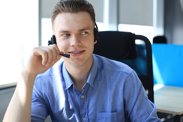 Smiling friendly handsome young male call centre operator.