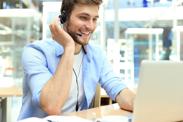 Smiling friendly handsome young male call centre operator.