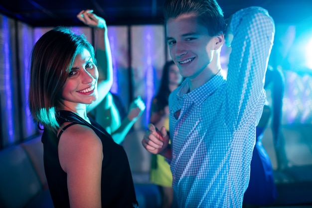 Photo smiling friends dancing on dance floor