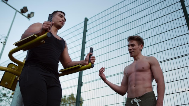 Smiling friends training workout together in sport playground outdoor