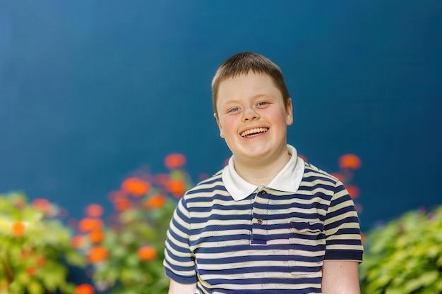 Photo smiling from ear to ear a teenage down syndrome boy looking at the camera smiling and looking happy