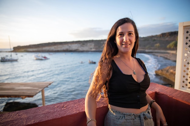 Smiling girl in a balcony overlooking the sea summer vacation photo with copy space