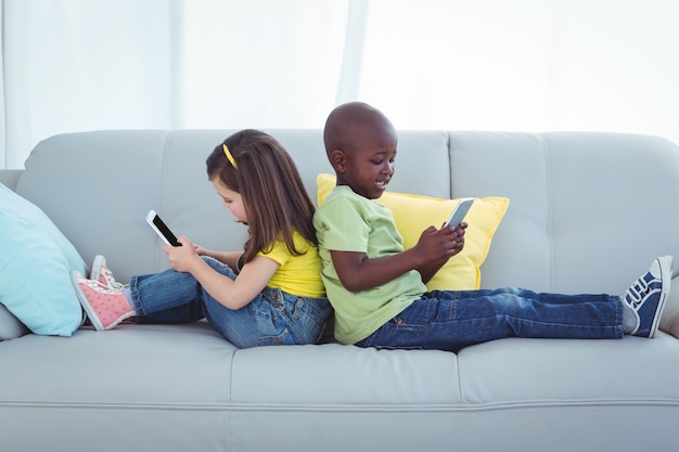 Smiling girl and boy using mobile phones