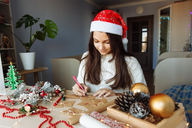 a smiling girl in a Christmas hat makes an advent calendar