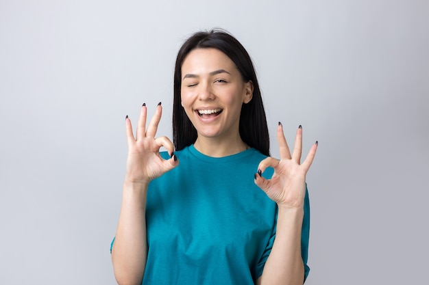 Smiling girl gesturing OK sign with her hand