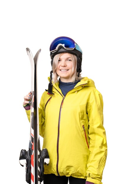 Smiling girl in helmet holding skis