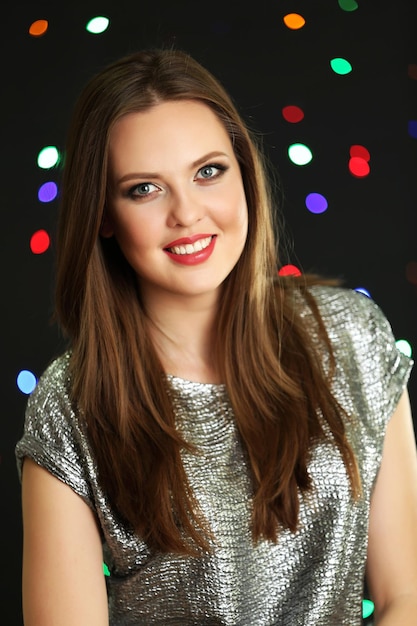 Smiling girl on multicolor lights background