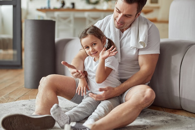 Smiling girl playing with father in living room