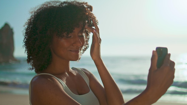 Smiling girl posing smartphone making selfie at beach close up Portrait woman