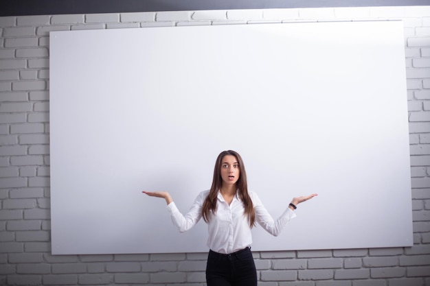 Smiling girl student or woman teacher portrait on white wall