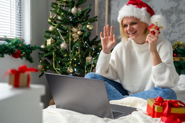 Smiling girl using laptop notebook for video call friends and parents Christmas online family congratulations