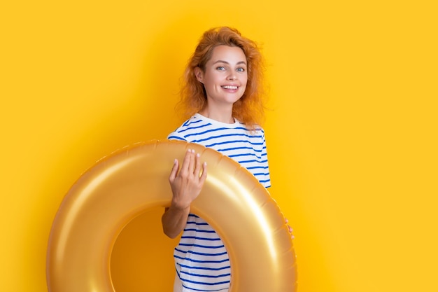 Photo smiling girl with inflatable ring isolated on yellow background summer vacation