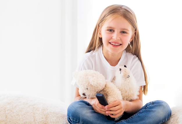 Smiling girl with toys in light room