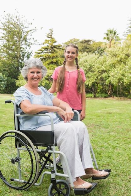 Smiling granddaughter with grandmother in her wheelchair 