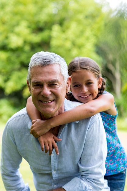 Smiling grandfather with grandaughter at yard