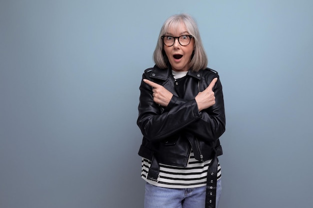 Smiling grayhaired middleaged woman in a rocker jacket on a bright background with copy space