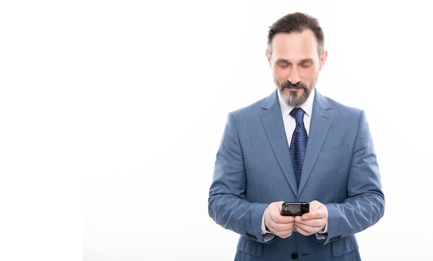 Smiling grizzled ceo texting on smartphone isolated on white copy space business communication