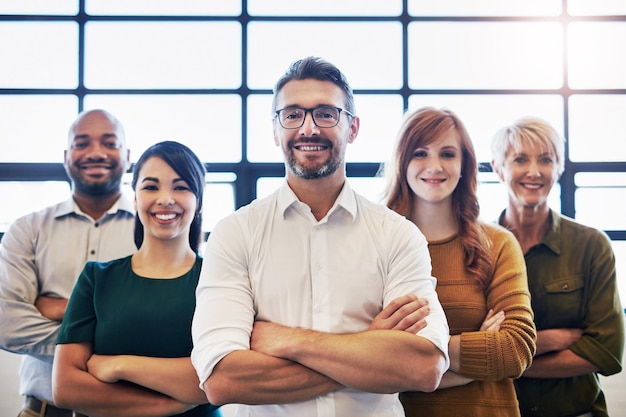 Smiling group of confident diverse and modern business people standing arms crossed with leadership quality Professional team of work colleagues proud with unity together in modern office