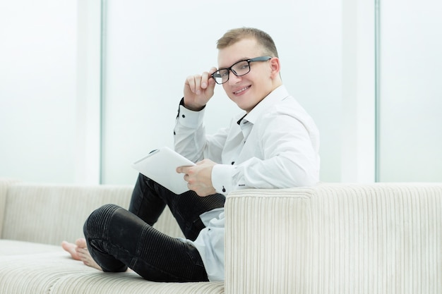 Smiling guy looking through media files on his tablet