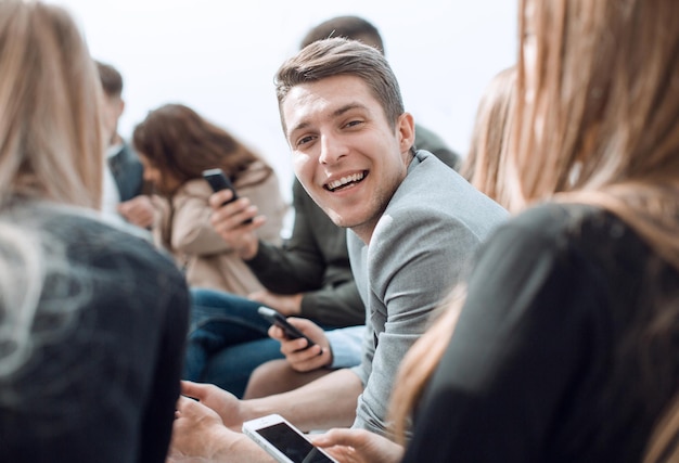 Photo smiling guy sitting in a circle at a group meeting