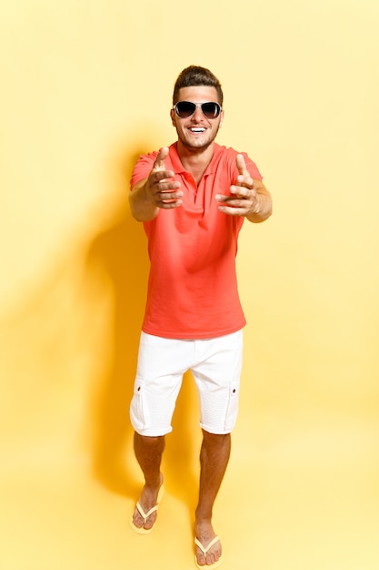 Smiling guy in sunglasses stepping towards camera