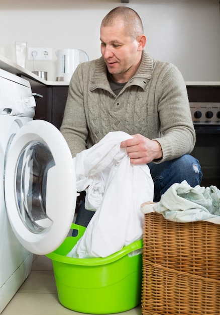 Smiling guy using washing machine