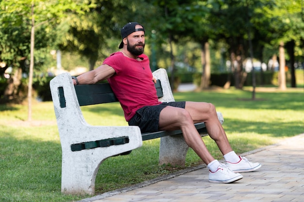 Smiling Handsome Guy Resting on Bench Outdoors