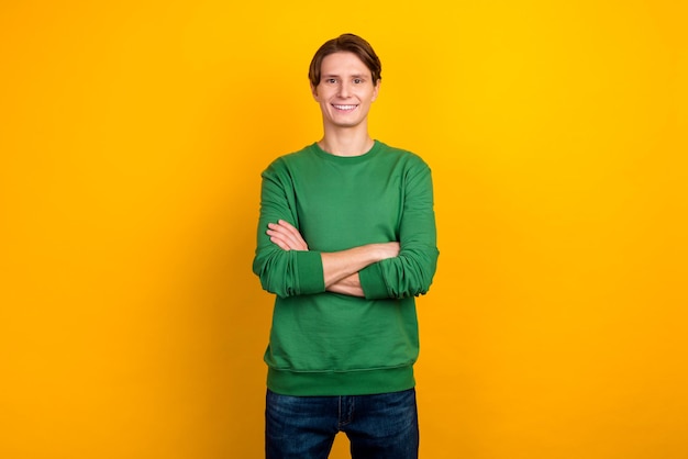 Smiling handsome man in shirt jeans standing with crossed arms isolated on bright color background