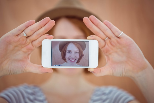 smiling hipster woman taking a selfie