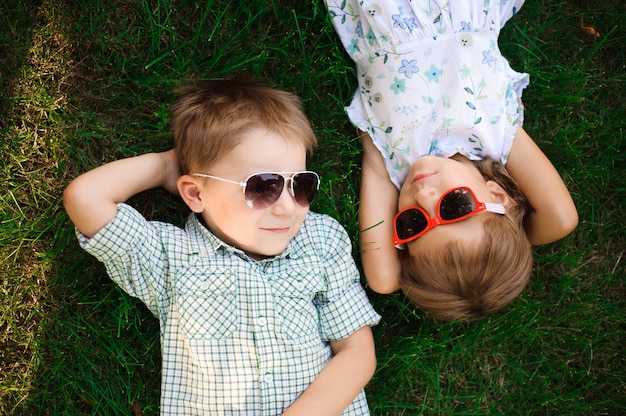 Smiling kids at the garden in sunglasses